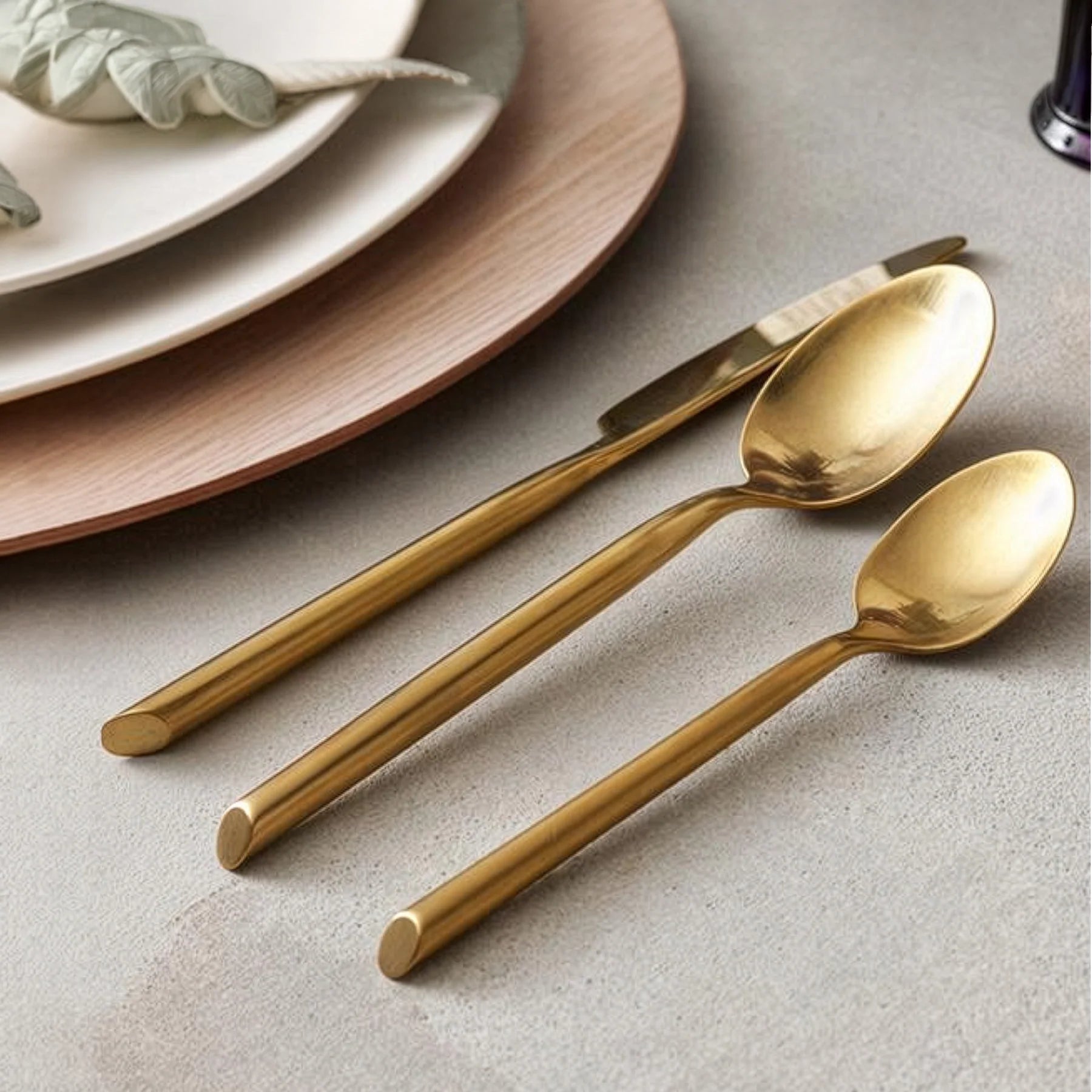 Montaje de mesa majestuoso y de estilo contemporáneo en el restaurante de un hotel servido con la cubertería dorada Capri Brushed Gold de Fortessa.