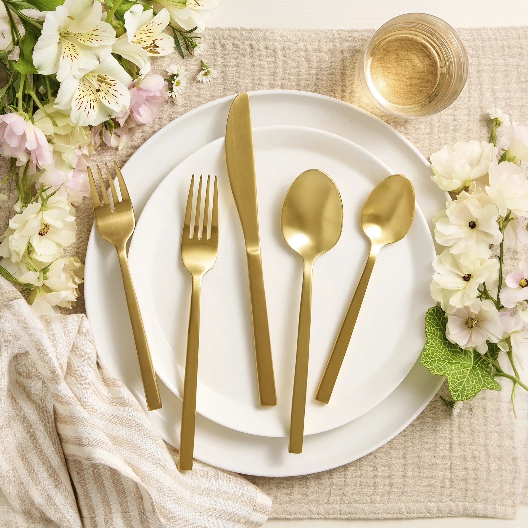 Montaje de mesa majestuoso y de estilo contemporáneo en el salón de un hotel servido con la cubertería de lujo Arezzo Brushed Gold de Fortessa.