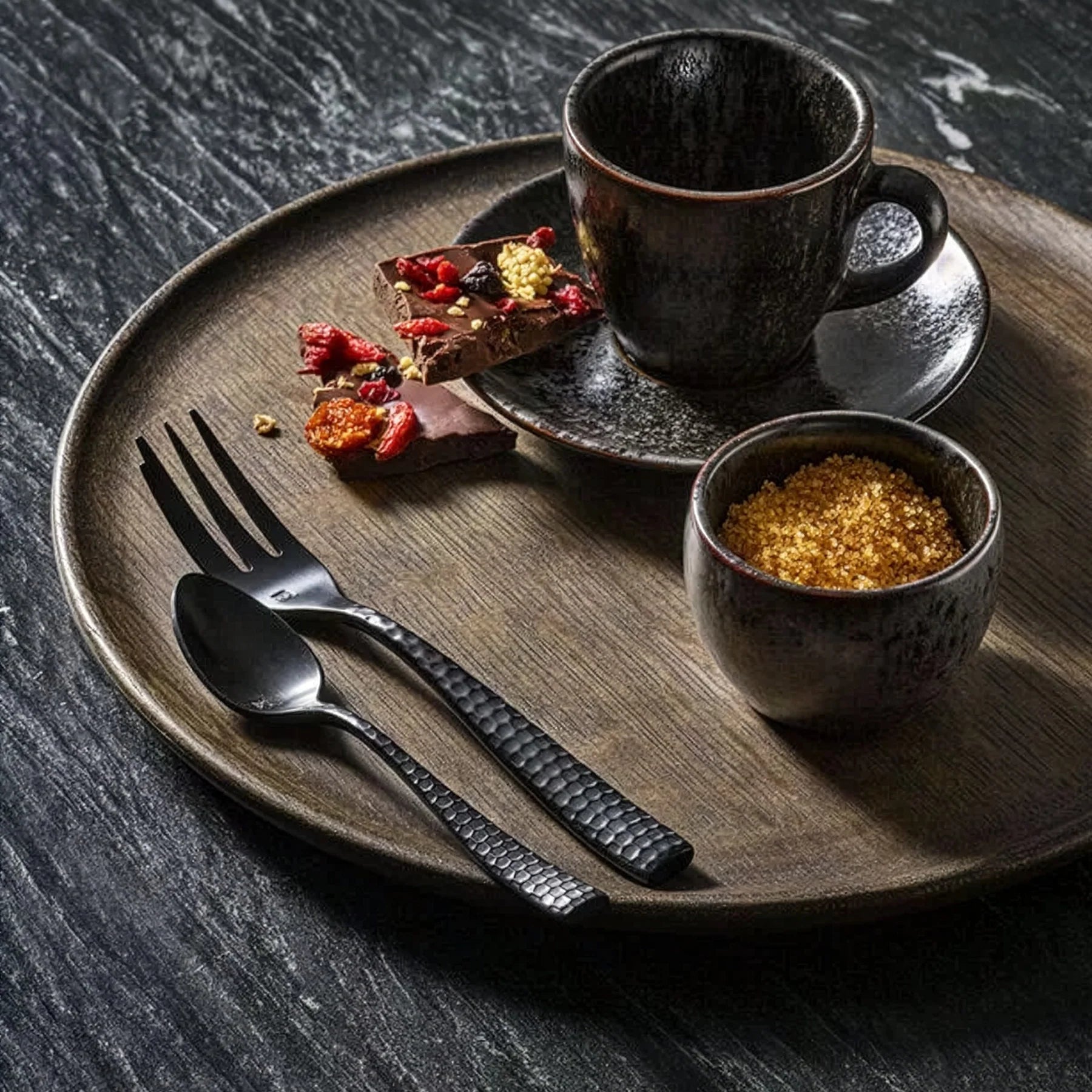 Montaje de mesa vanguardista y de estilo minimalista-chic en el restaurante de un hotel servido con la cubertería negra Lucca Facet Black de Fortessa.