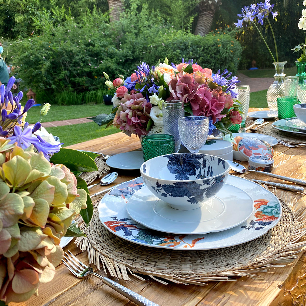 Conjunto de platos de una vajilla floral de porcelana con estampados de flores grandes y coloridas.
