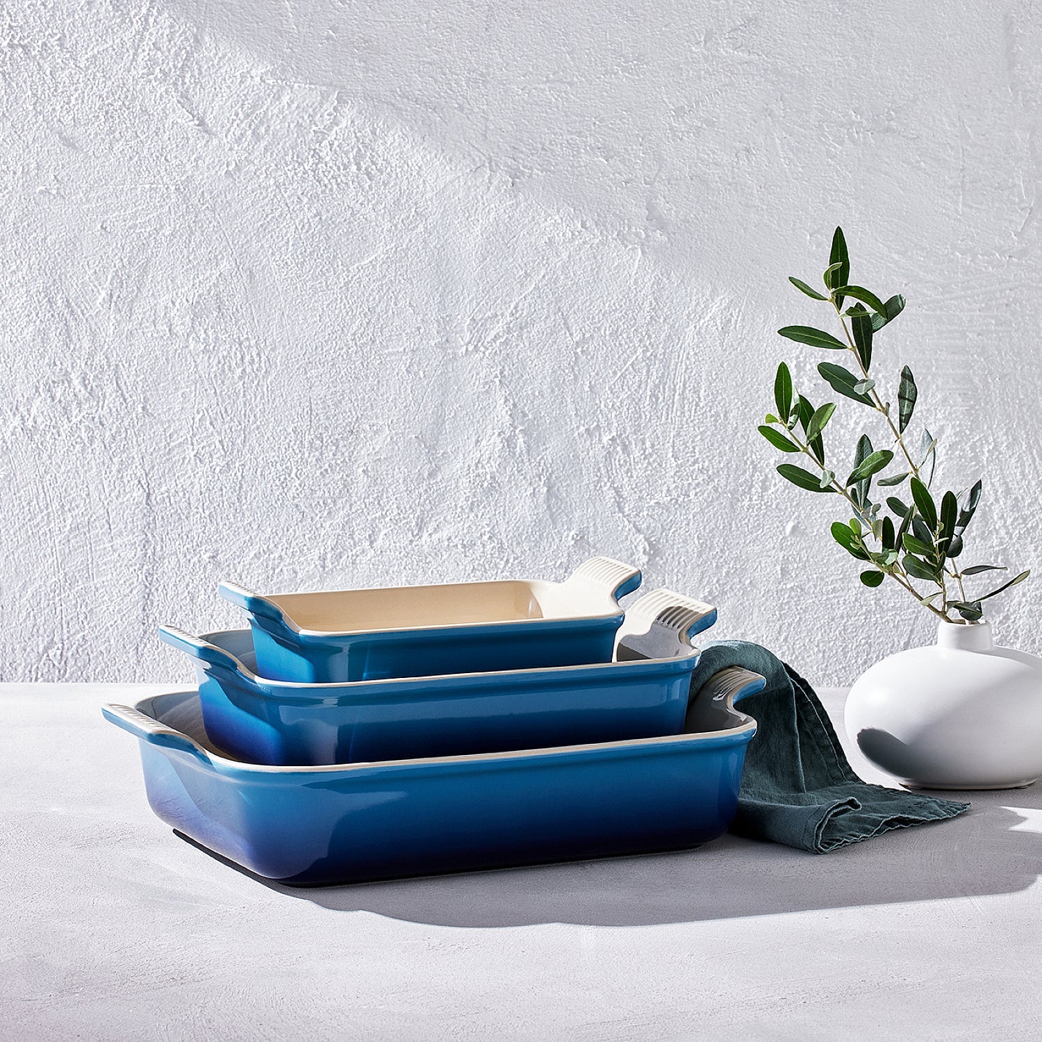 Primer plano de unas refractarias Le Creuset de cerámica, sobre una mesa blanca.