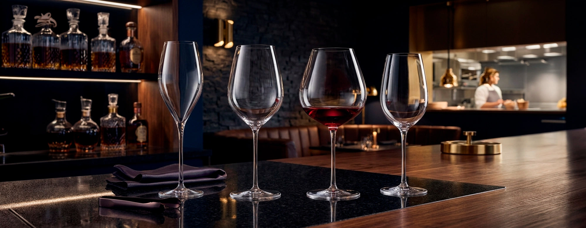 Mesa de bar servida con la elegante cristalería Fino en un restaurante elegante con luz ambiente.